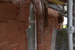 Window to left of porch - one head good, one very worn